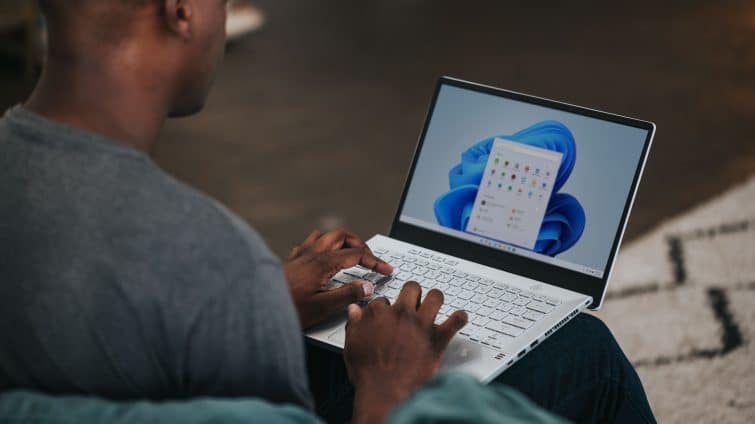 man in gray long sleeve shirt using Windows 11 computer